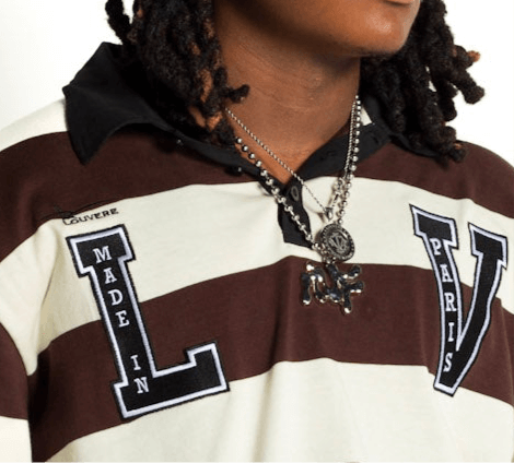 Close-up of a person wearing a Louvere shirt with 'MADE IN PARIS' and 'LV' embroidered designs, showcasing stylish streetwear fashion.